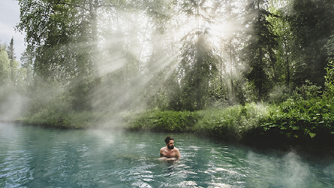 person sitting in hot springs water