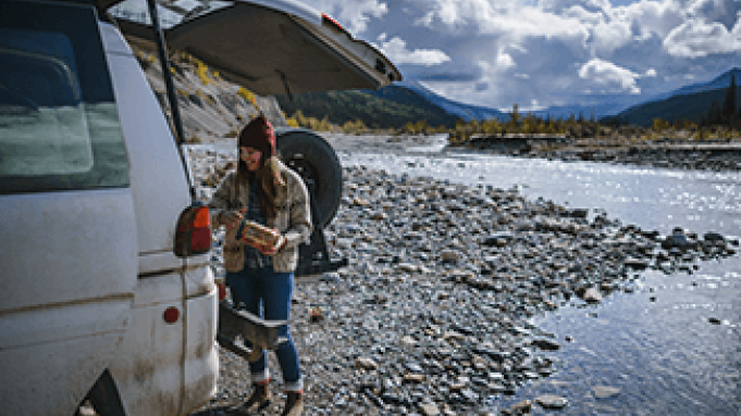 person and vehicle beside river