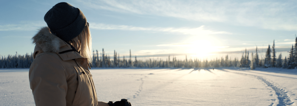 person looking out on snow cover lake